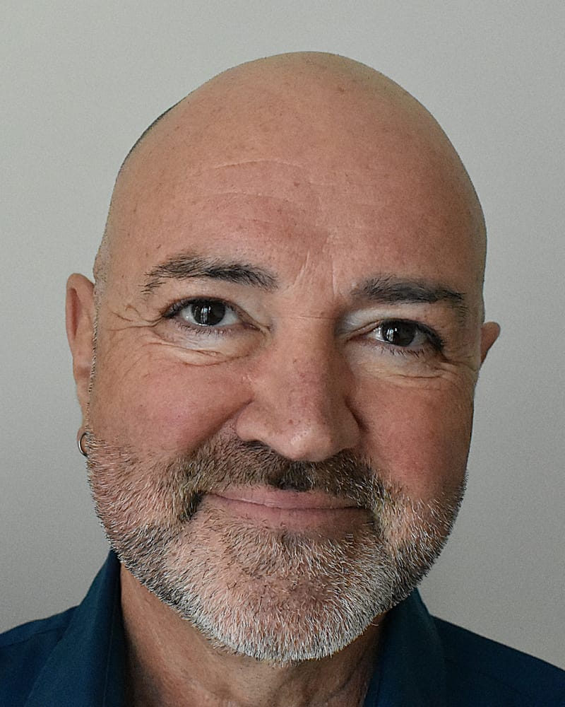 Paul Scott-Williams, smiling warmly, in a dark blue shirt